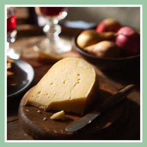 Aged cheese wedge with sliced apples on a wooden board