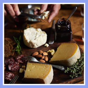 Soft cheese with jam and crackers on a rustic serving board