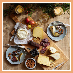 Maine cheese board with crackers, jam, and cider for sharing